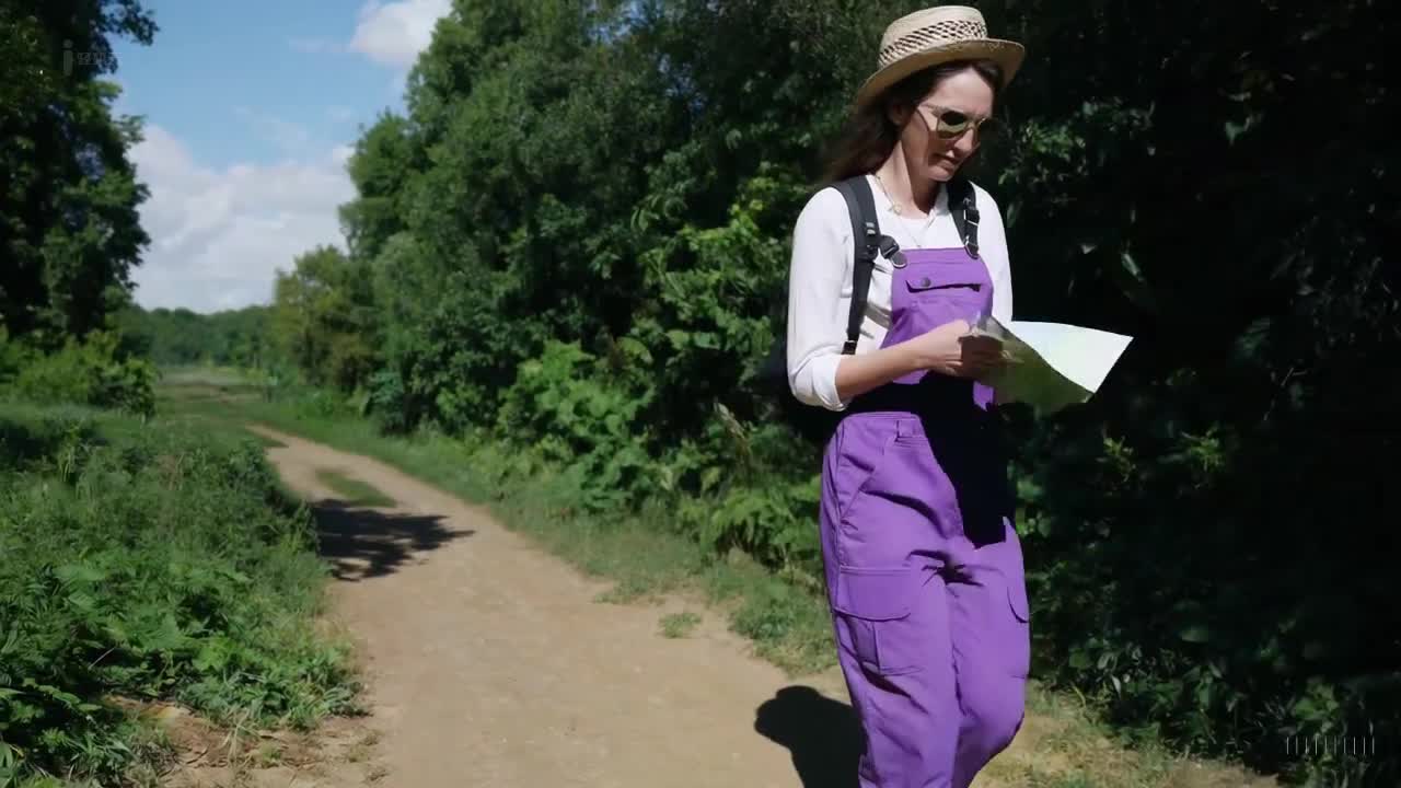 一个穿着紫色工装裤和牛仔靴的女人在印度孟买美丽的日落时分愉快地散步。